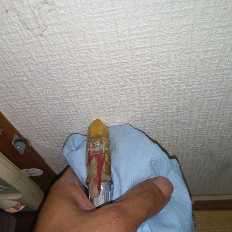 トイレの壁にシロアリ駆除剤を注入する様子