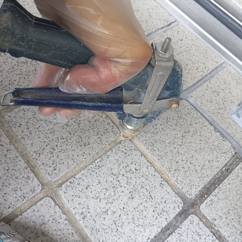 玄関の床にシロアリ駆除剤を注入する様子