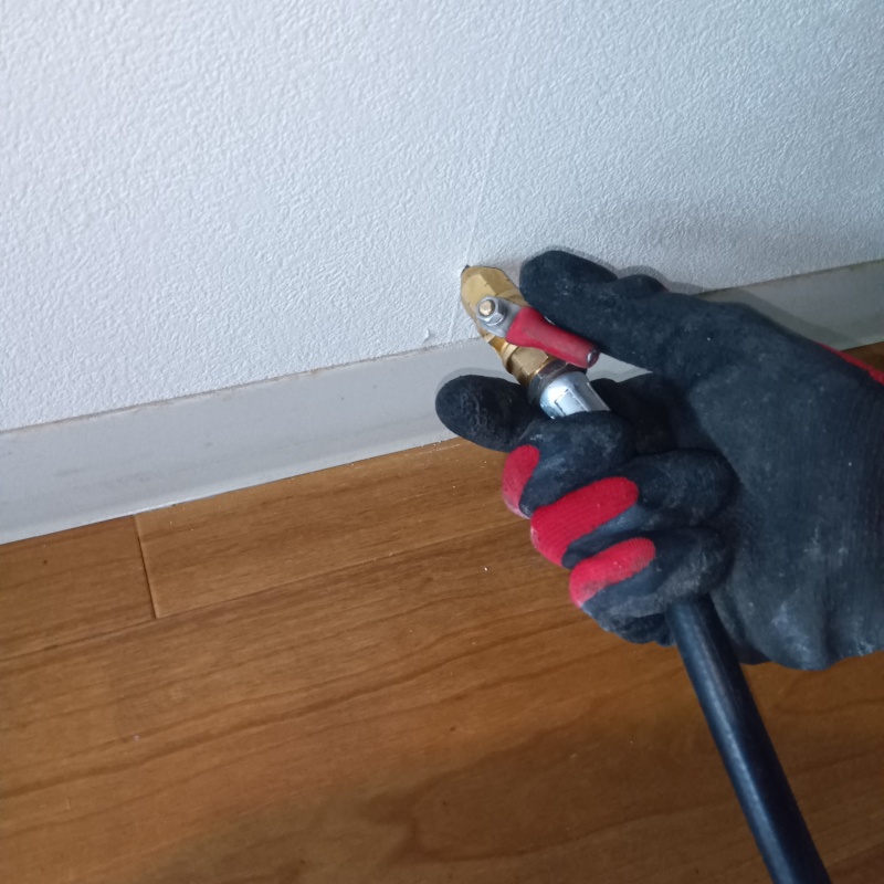 廊下の壁にシロアリ駆除剤を注入する様子