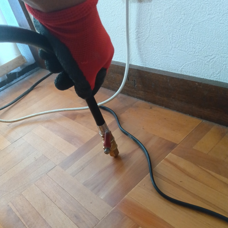 洗面所の床にシロアリ駆除剤を注入する様子