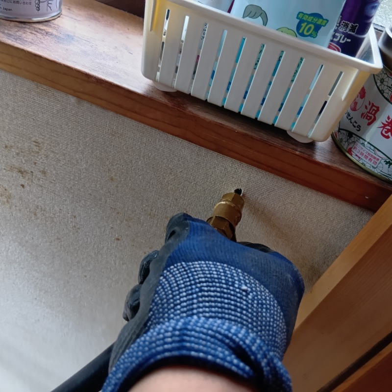 トイレの壁にシロアリ駆除剤を注入する様子