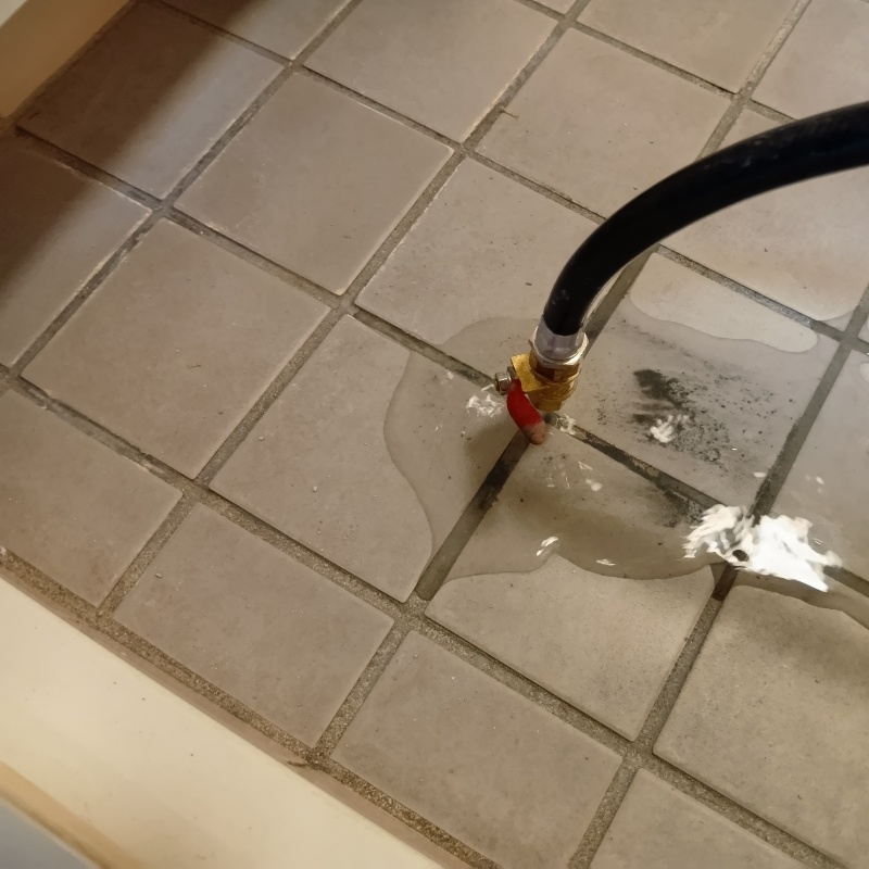 浴室の床にシロアリ駆除剤を注入する様子