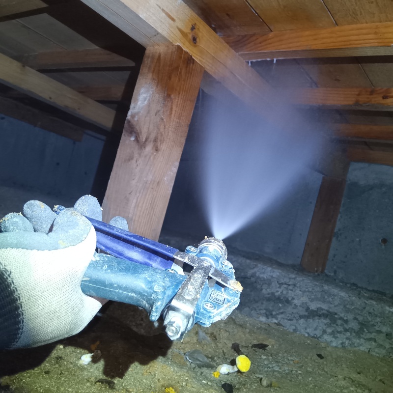 床下の木材にシロアリ駆除剤を散布する様子