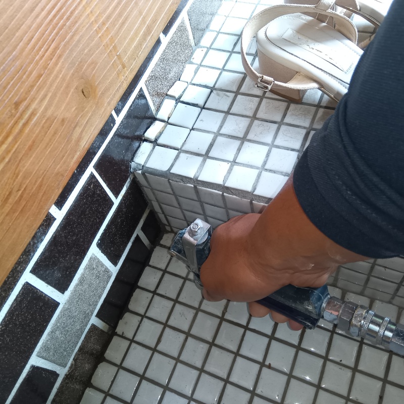 玄関の床にシロアリ駆除剤を注入する様子