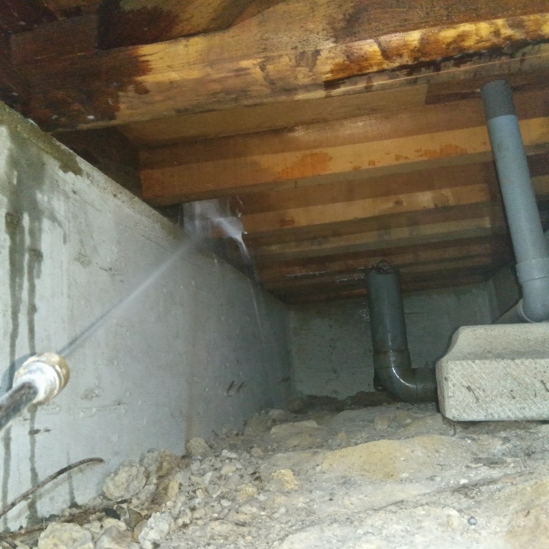 床下の木材にシロアリ駆除剤を散布する様子