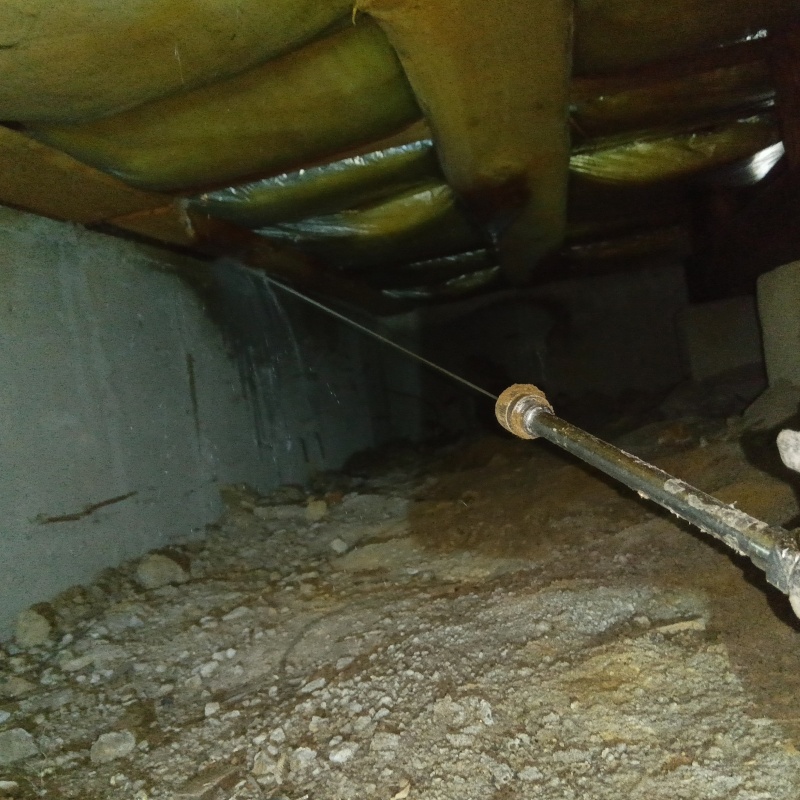 床下の基礎部分にシロアリ駆除剤を散布する様子