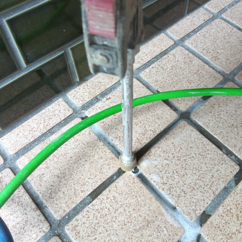 玄関の床にシロアリ駆除剤を注入する様子