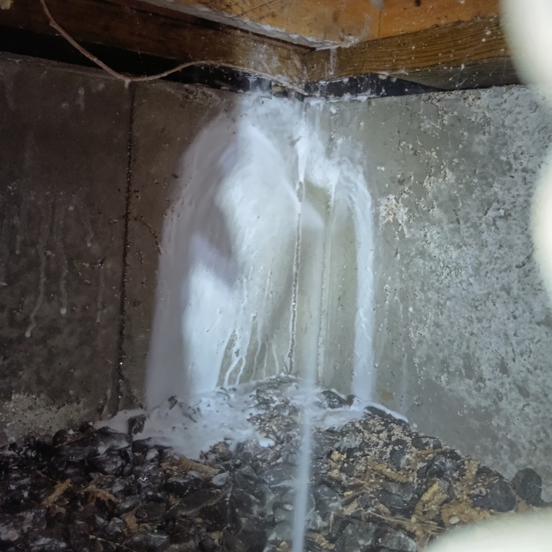 床下の基礎部分にシロアリ駆除剤を散布する様子