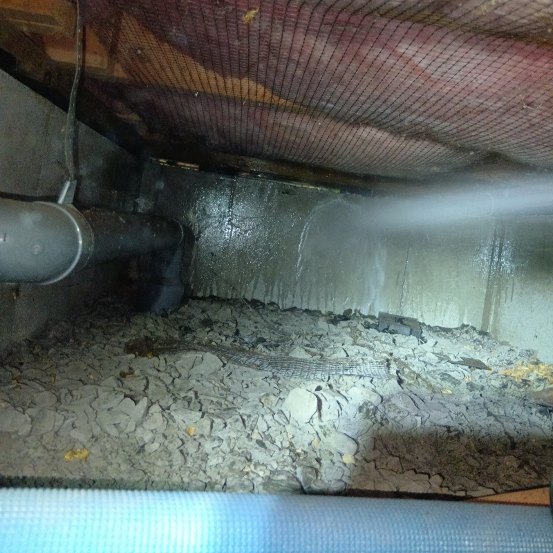 床下の基礎部分にシロアリ駆除剤を散布する様子
