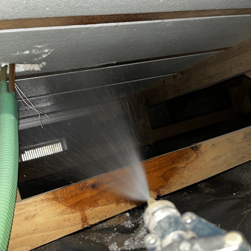 床下の木材にシロアリ駆除剤を散布する様子