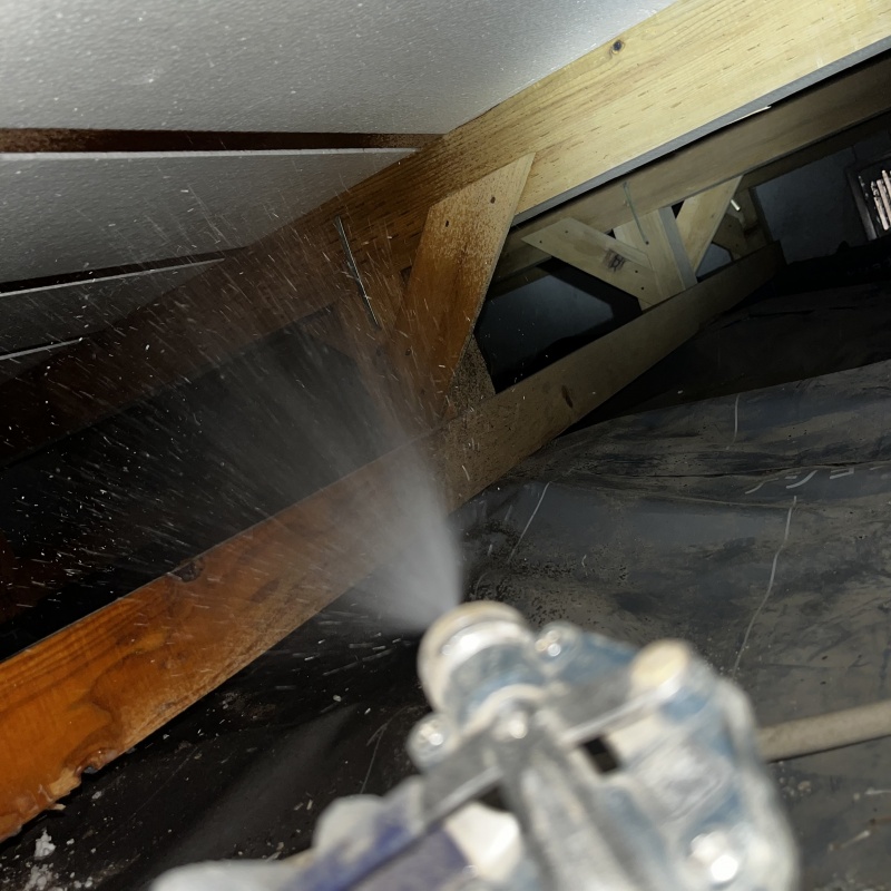 床下の木材にシロアリ駆除剤を散布する様子