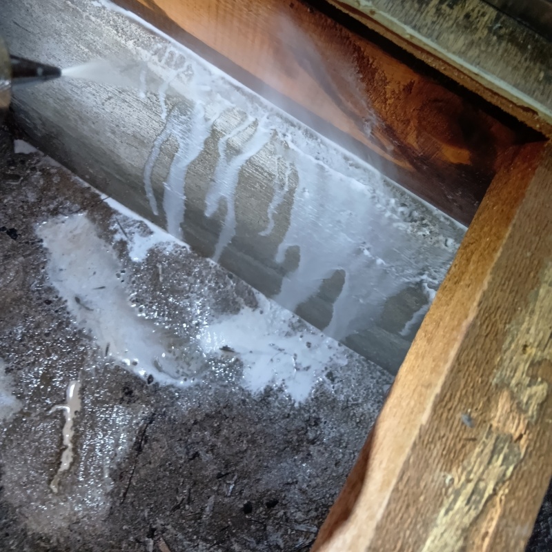 床下の基礎部分にシロアリ駆除剤を散布する様子