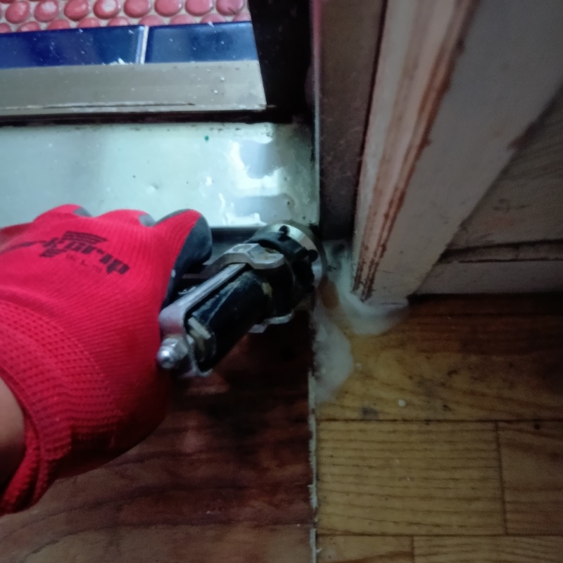 脱衣室の床にシロアリ駆除剤を注入する様子