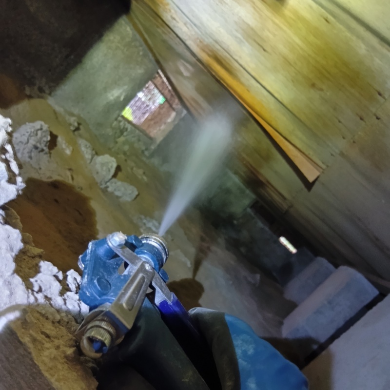 床下の木材にシロアリ駆除剤を散布する様子