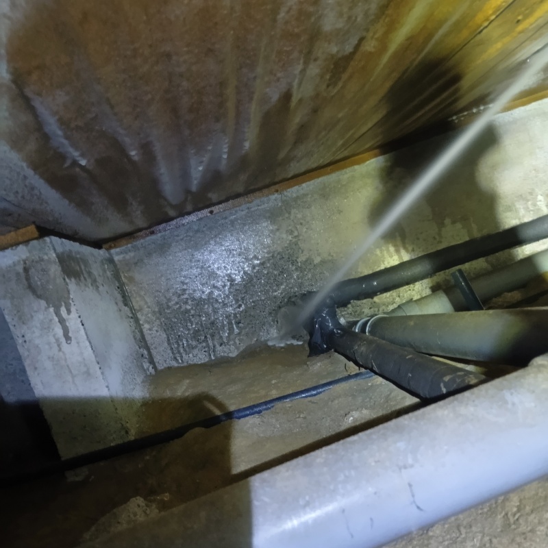 床下の基礎部分にシロアリ駆除剤を散布する様子