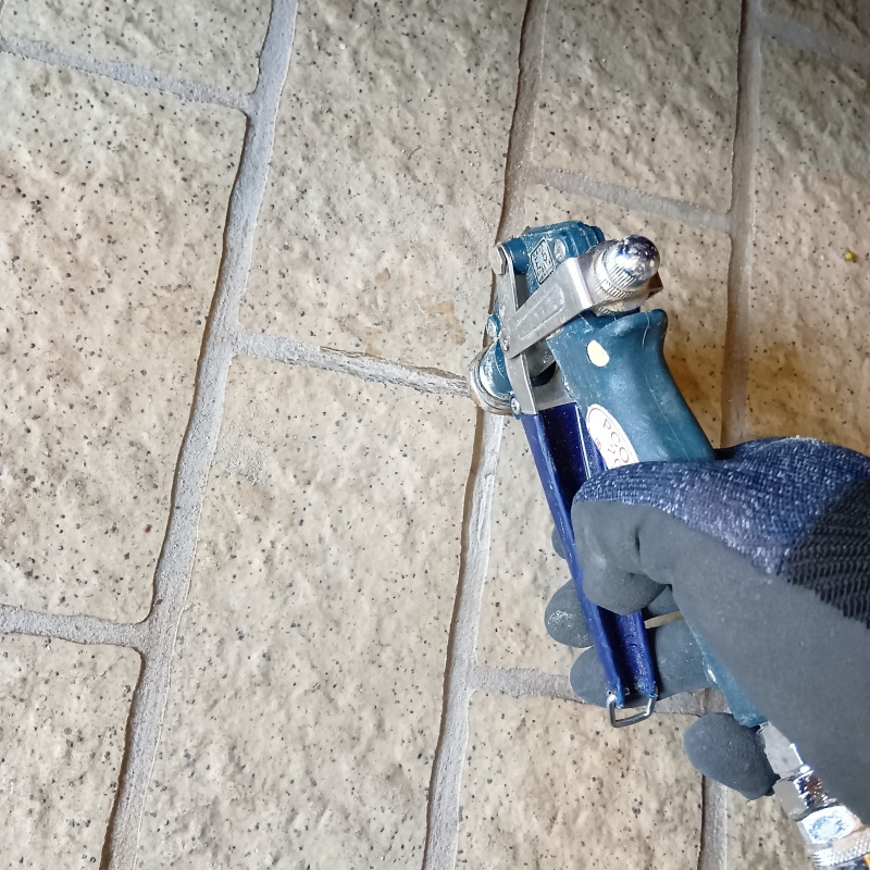 玄関の床にシロアリ駆除剤を注入する様子