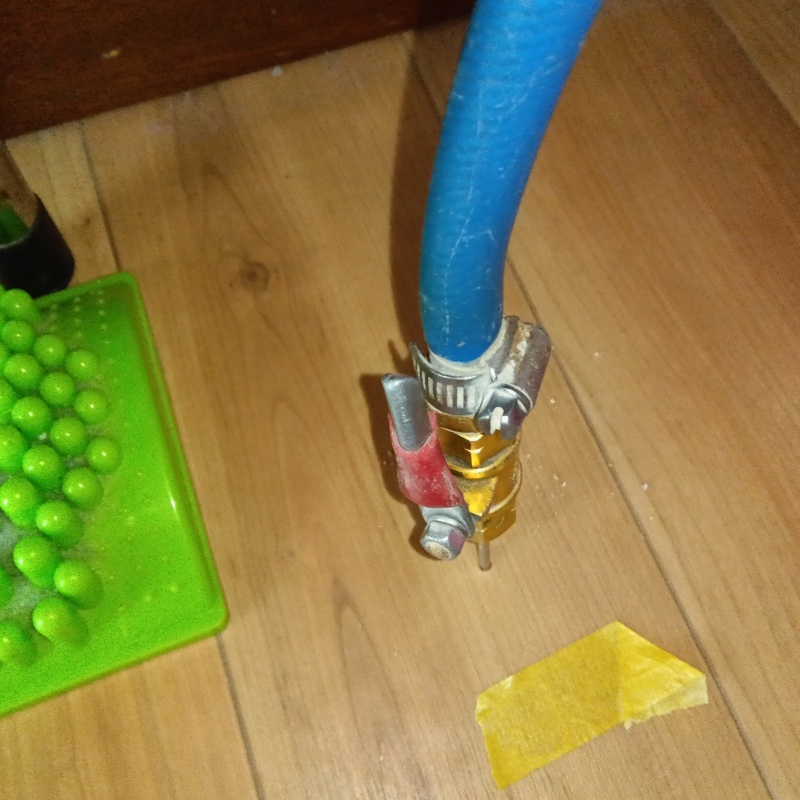 居間の床にシロアリ駆除剤を注入する様子