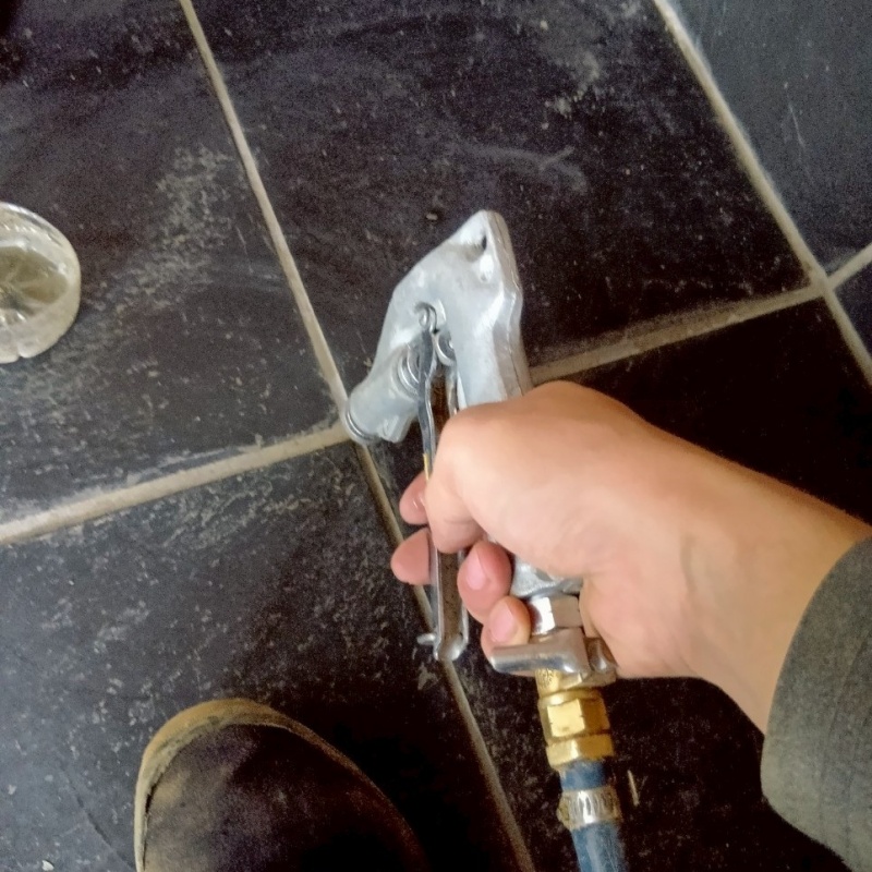 玄関の床にシロアリ駆除剤を注入する様子