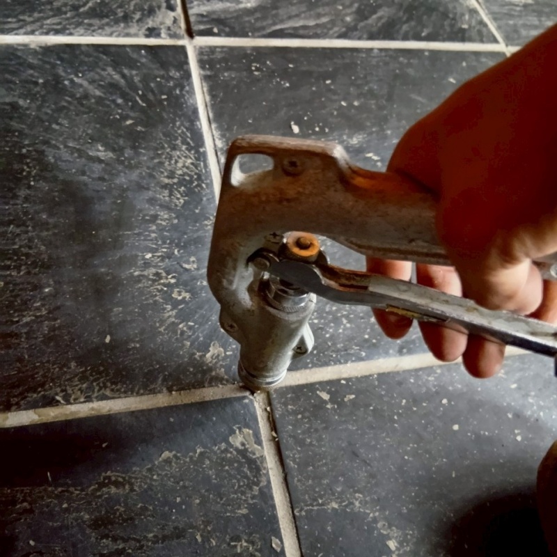 玄関の床にシロアリ駆除剤を注入する様子