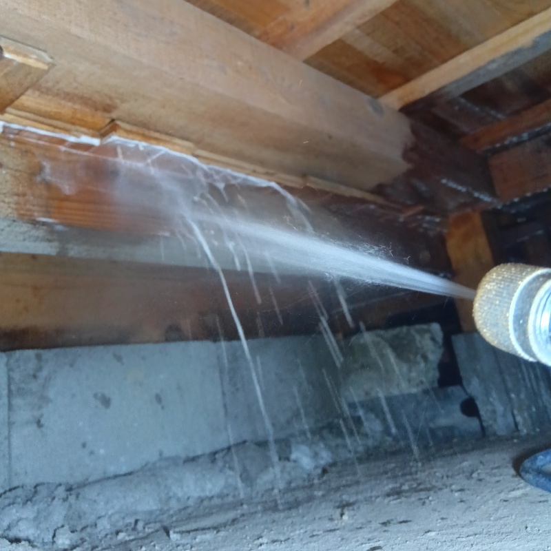 床下の木材にシロアリ駆除剤を散布する様子