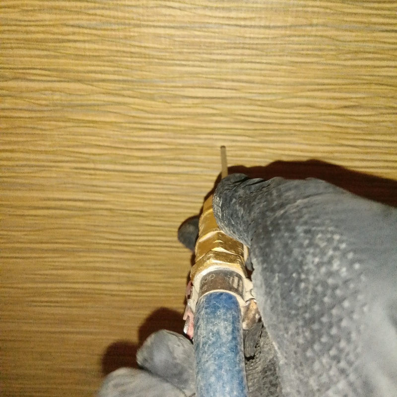 キッチンの壁にシロアリ駆除剤を注入する様子