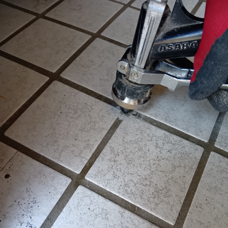 玄関の床に防蟻剤を注入する様子