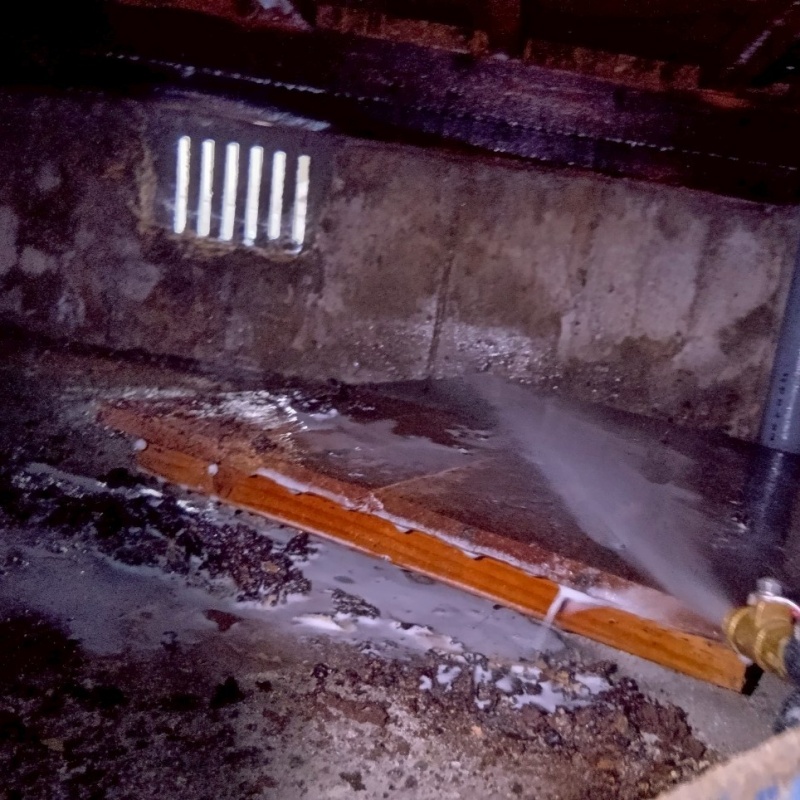 床下の土壌にシロアリ駆除剤を散布する様子