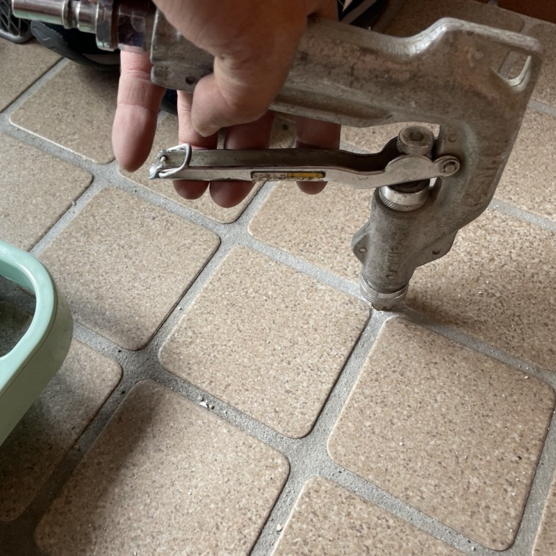 玄関の床にシロアリ駆除剤を注入する様子