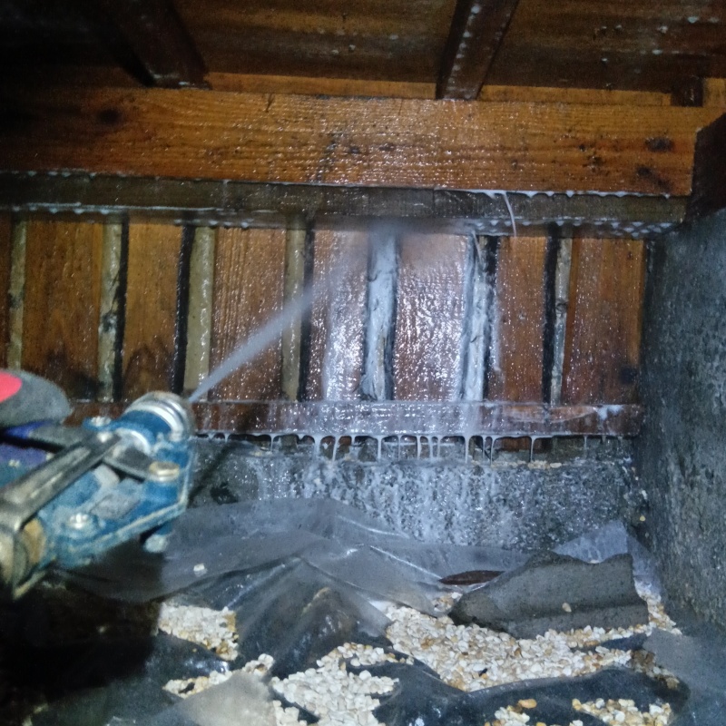 床下の木材にシロアリ駆除剤を散布する様子