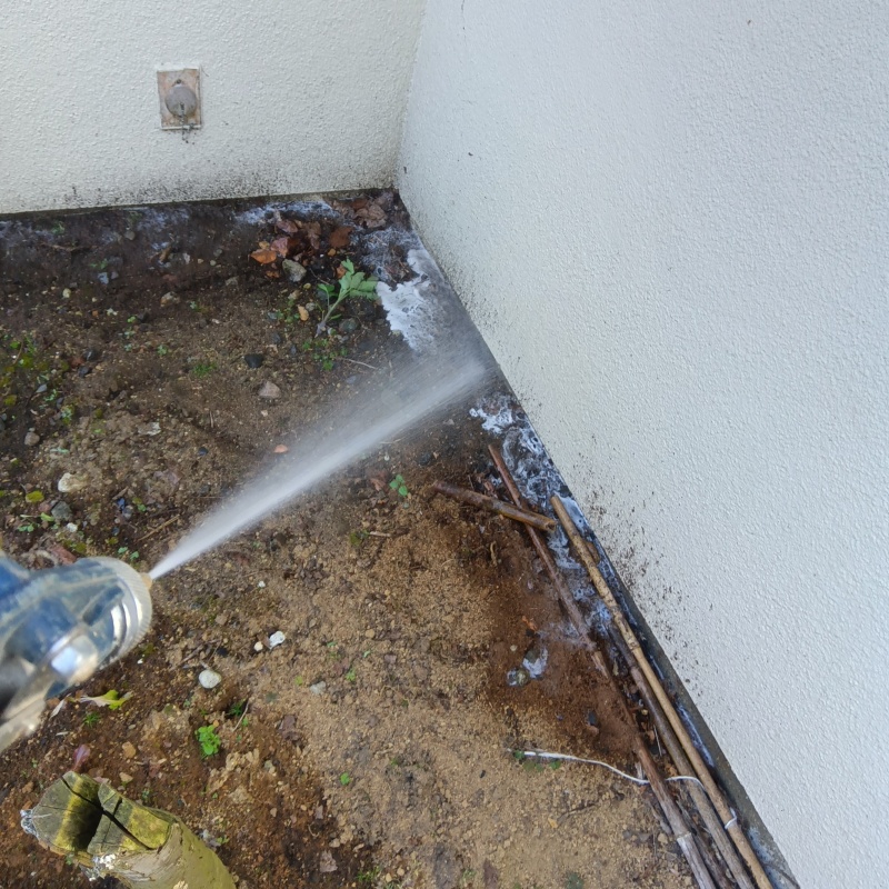 基礎まわりにシロアリ駆除剤を散布する様子