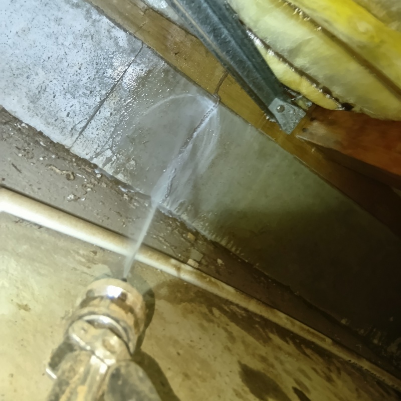 床下の基礎部分にシロアリ駆除剤を散布する様子