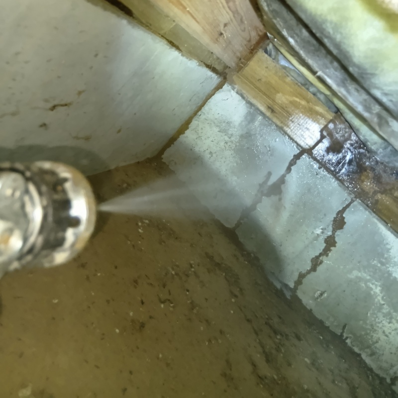 床下の基礎部分にシロアリ駆除剤を散布する様子