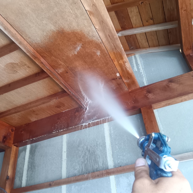 土間の天井木材にシロアリ駆除剤を散布する様子