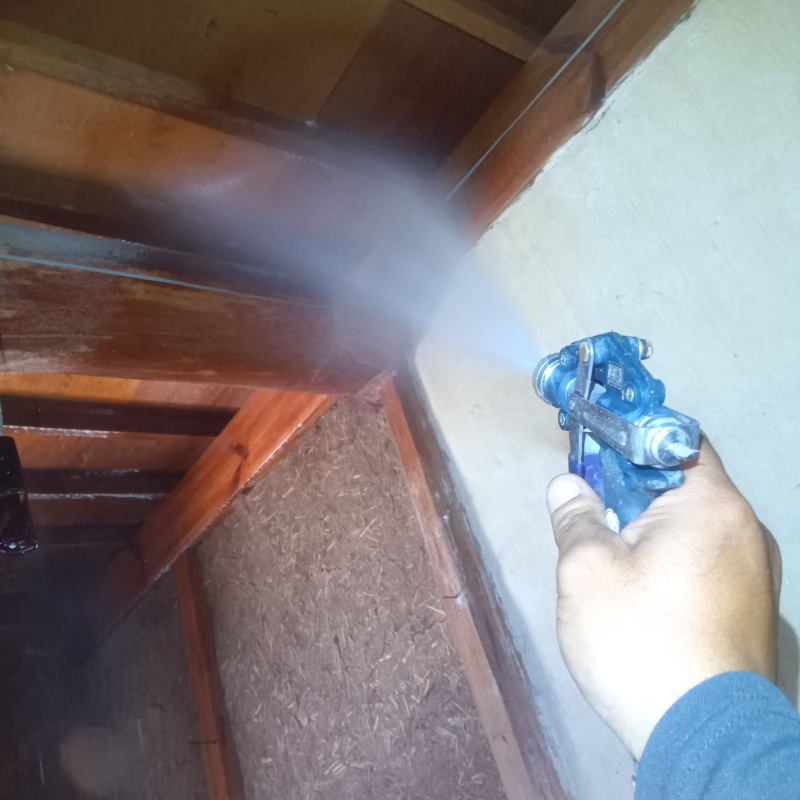 土間の天井木材にシロアリ駆除剤を散布する様子