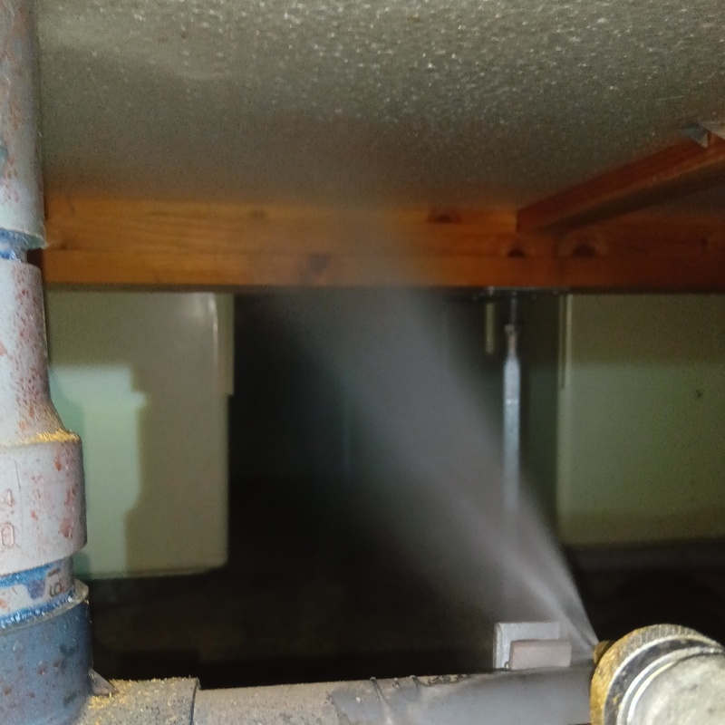 床下の木材にシロアリ駆除剤を散布する様子