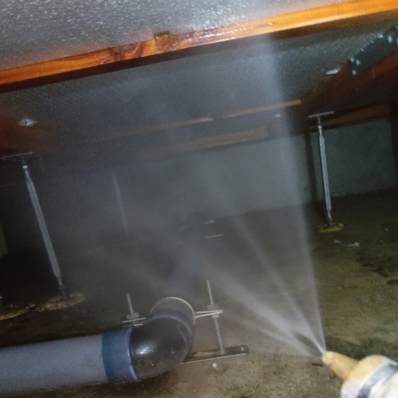 床下の木材にシロアリ駆除剤を散布する様子