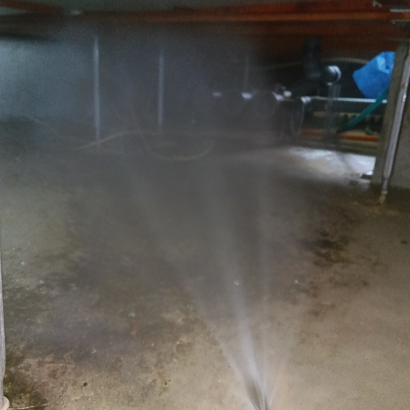 床下の土壌にシロアリ駆除剤を散布する様子