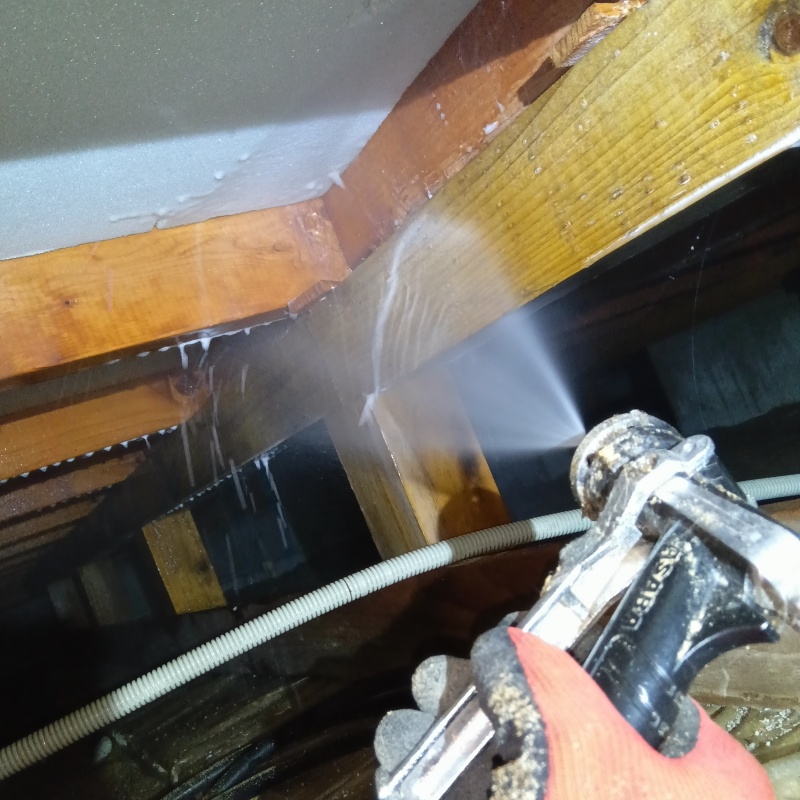 床下の木材にシロアリ駆除剤を散布する様子