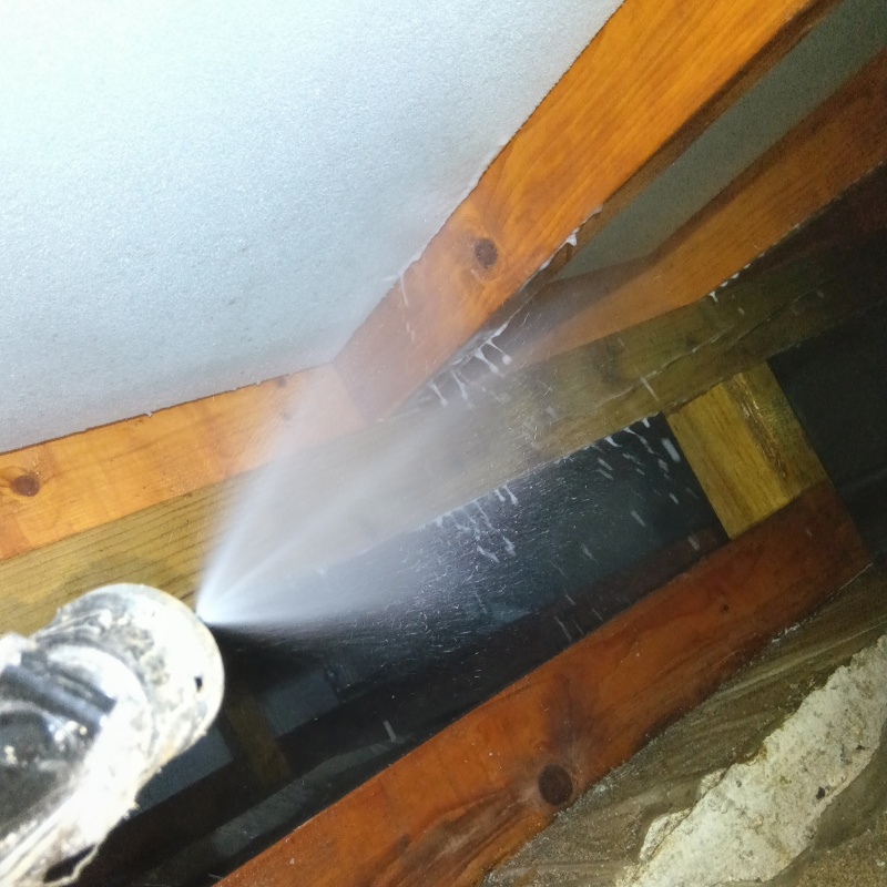 床下の木材にシロアリ駆除剤を散布する様子