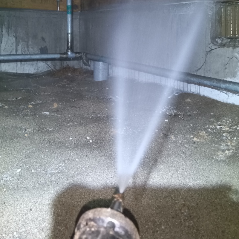 床下の基礎部分にシロアリ駆除剤を散布する様子