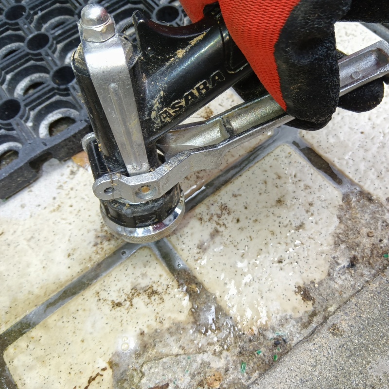 玄関の床にシロアリ駆除剤を注入する様子