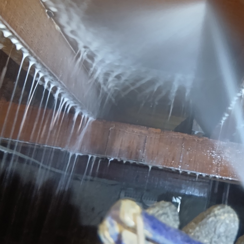 床下の木材にシロアリ駆除剤を散布する様子