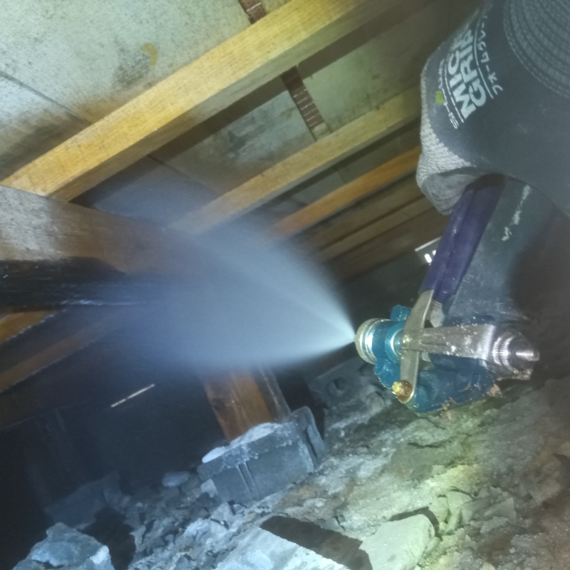 床下の木材にシロアリ駆除剤を散布する様子