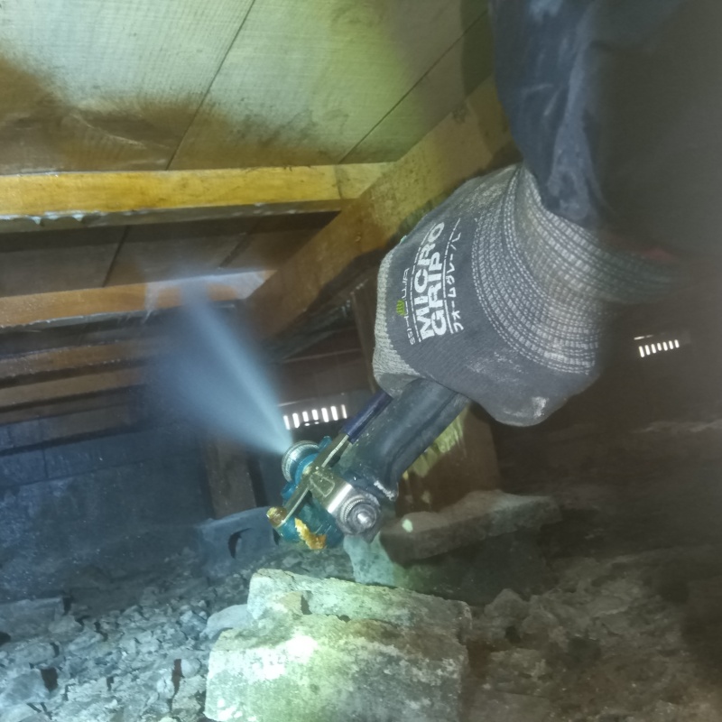 床下の木材にシロアリ駆除剤を散布する様子