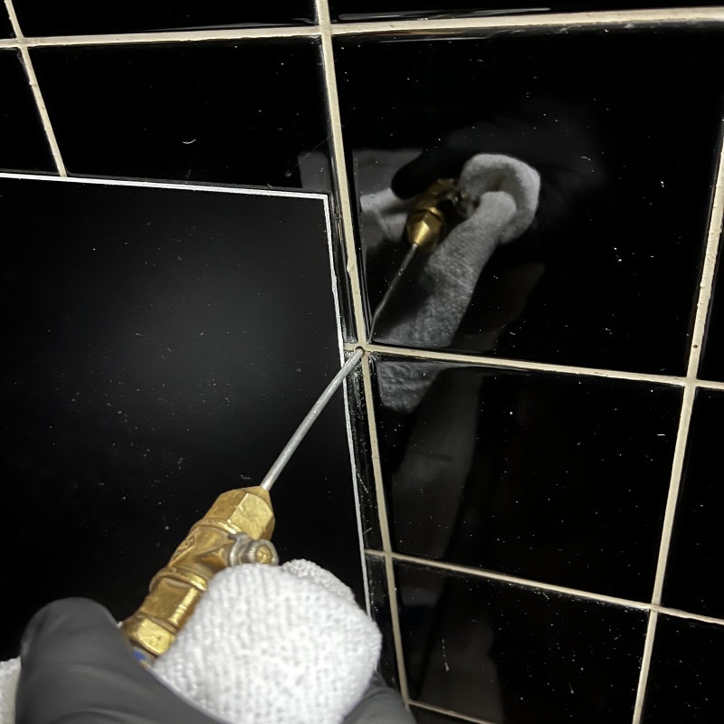 台所の壁にシロアリ駆除剤を注入する様子