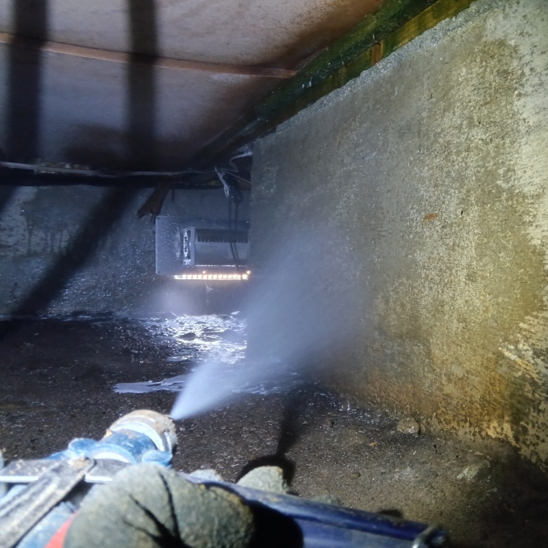 床下の基礎部分にシロアリ駆除剤を散布する様子