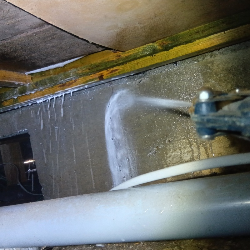 床下の基礎部分にシロアリ駆除剤を散布する様子