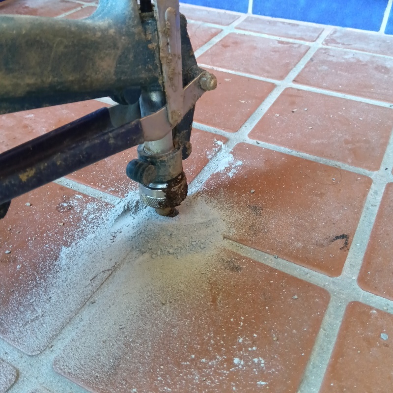 玄関の床にシロアリ駆除剤を注入する様子