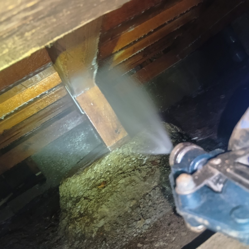 床下の木材にシロアリ駆除剤を散布する様子