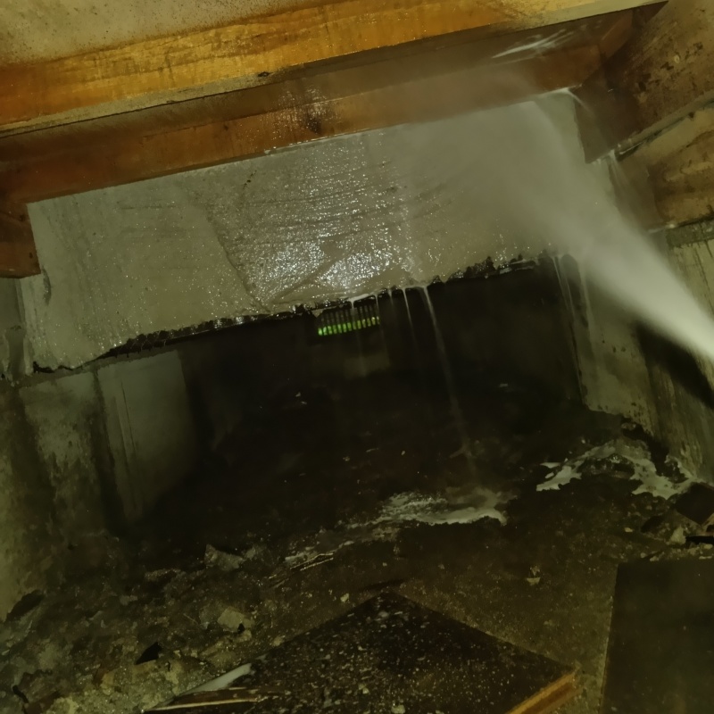 床下の基礎部分にシロアリ駆除剤を散布する様子